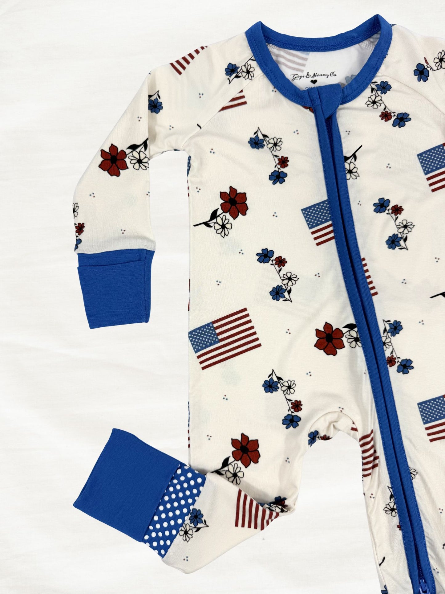 Baby zippy with American flag pattern and blue accents on a white background
